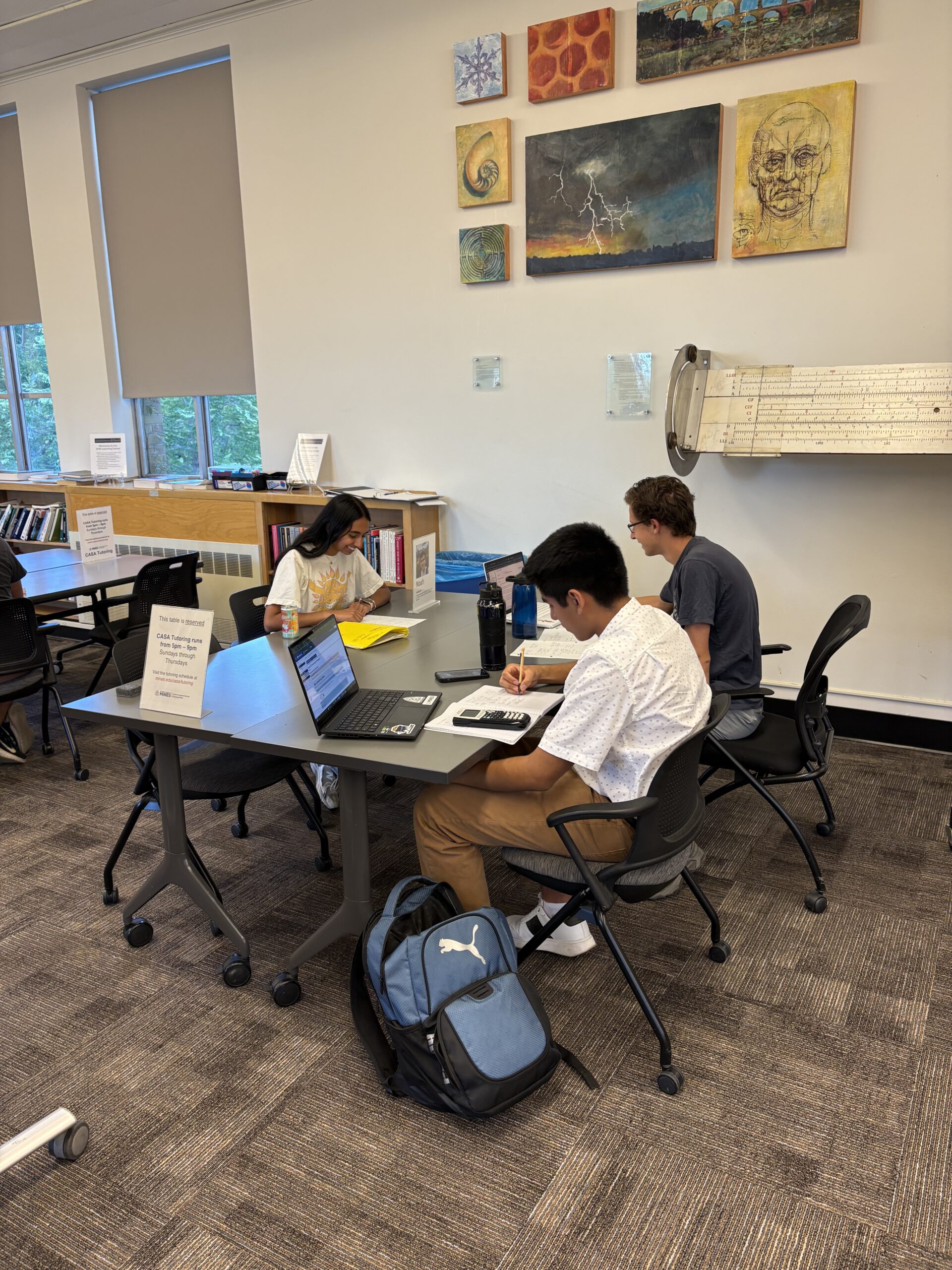 Three people studying at a table.